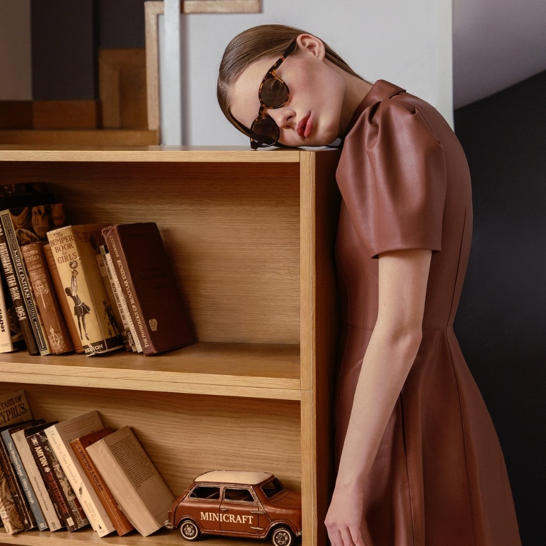 a man standing in front of a book shelf filled with books 